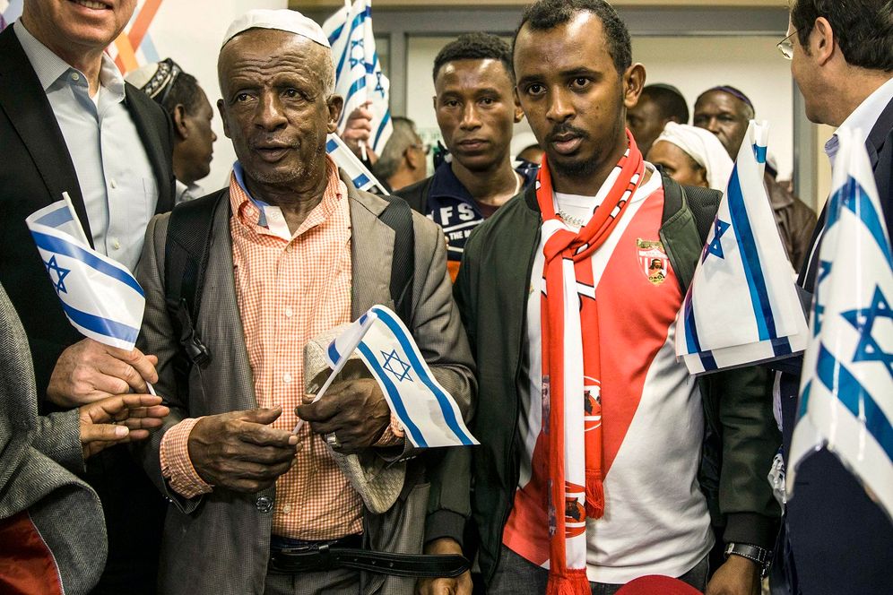 FILE - Ethiopian Jews hold Israeli flags at the Ben Gurion airport near Tel Aviv, Israel, Monday, Feb. 4, 2019