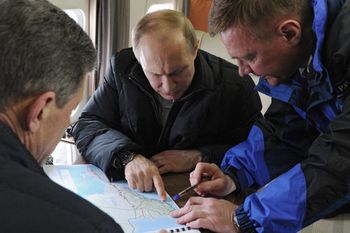 Russian President Vladimir Putin (C) points at the map of the Kerch strait, which links Russia and the Crimean peninsula.