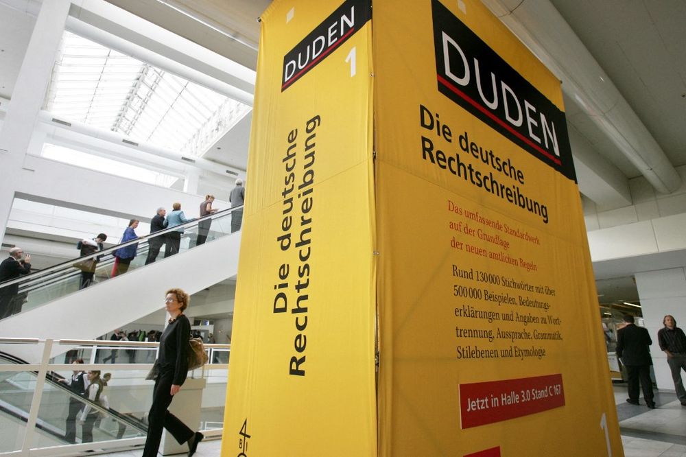 Fair-goers walk past an oversized Duden dictionary of "Correct German Spelling" at the international Frankfurt Book Fair in Germany on October 4, 2006.