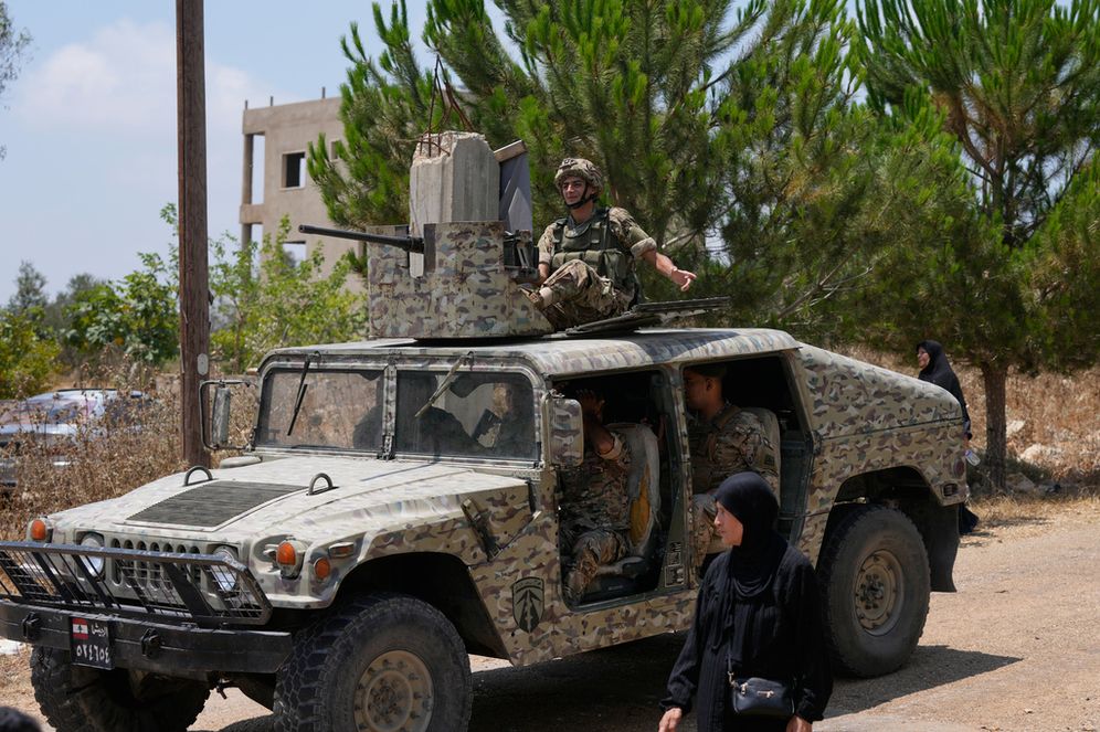 AP Photo/Mohammed Zaatari جنود من الجيش اللبناني يركبون مركبة عسكرية بينما تسير امرأة أمامهم عند دخول قرية زوتر الغربية الجنوبية في لبنان، الأربعاء 22 يوليو/تموز 2026.