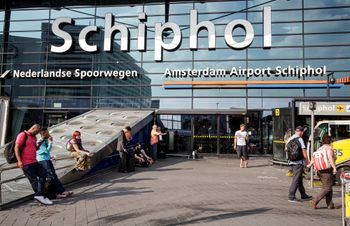 Des voyageurs font la queue pour l'enregistrement et l'embarquement à l'aéroport Schiphol d'Amsterdam, Pays-Bas