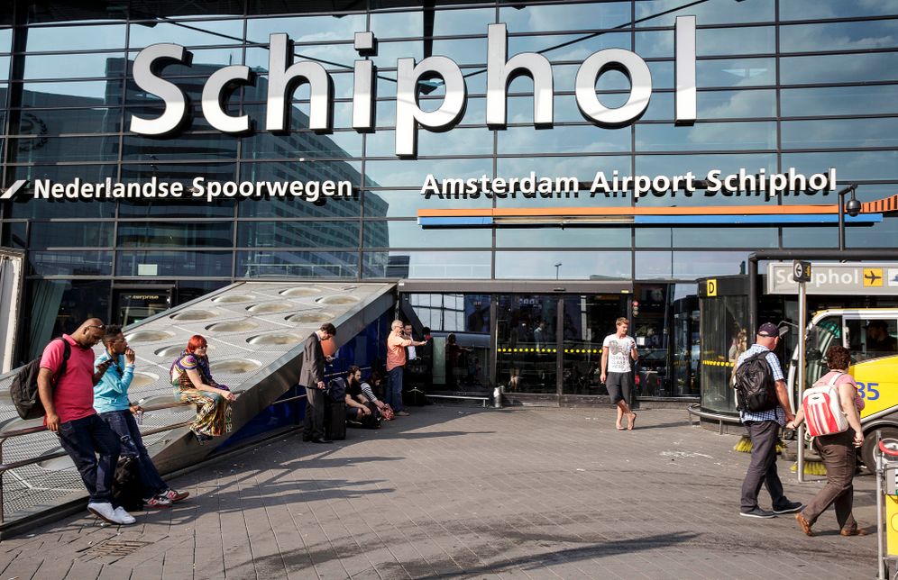 AP Photo/Peter Dejong, File Des voyageurs font la queue pour l'enregistrement et l'embarquement à l'aéroport Schiphol d'Amsterdam, Pays-Bas