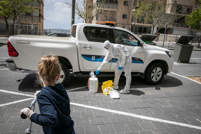 Des membres de l'équipe médicale de Magen David Adom, portant un équipement de protection, effectuent des tests de coronavirus auprès de patients à Jérusalem, le 17 avril 2020