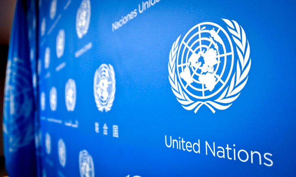 FILE - United Nations logo printed in various languages on a wall.
