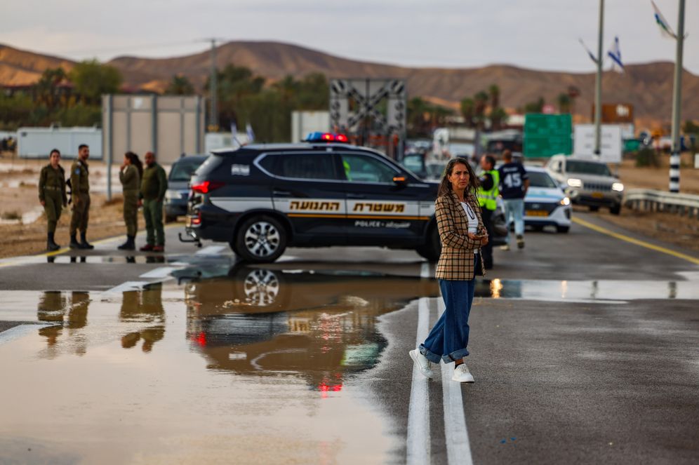 Photo by David Cohen/Flash90 People wait on the blocked Highway 90 in the Negev Desert, after it was flooded due to heavy rains, May 4, 2025.