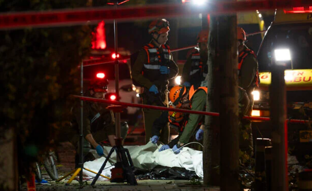 Forces de sécurité et de secours israéliennes sur les lieux où un missile tiré depuis l’Iran a tué une personne à Tel-Aviv, le 28 mars 2026. 