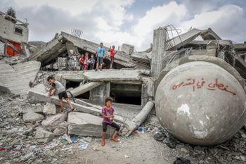 Palestinian children in front of a mosque destroyed in an Israeli air strike, near the Shaboura refugee camp, in light of the ongoing battles between Israel and Hamas, in the city of Rafah, southern Gaza Strip, on April 26, 2024.