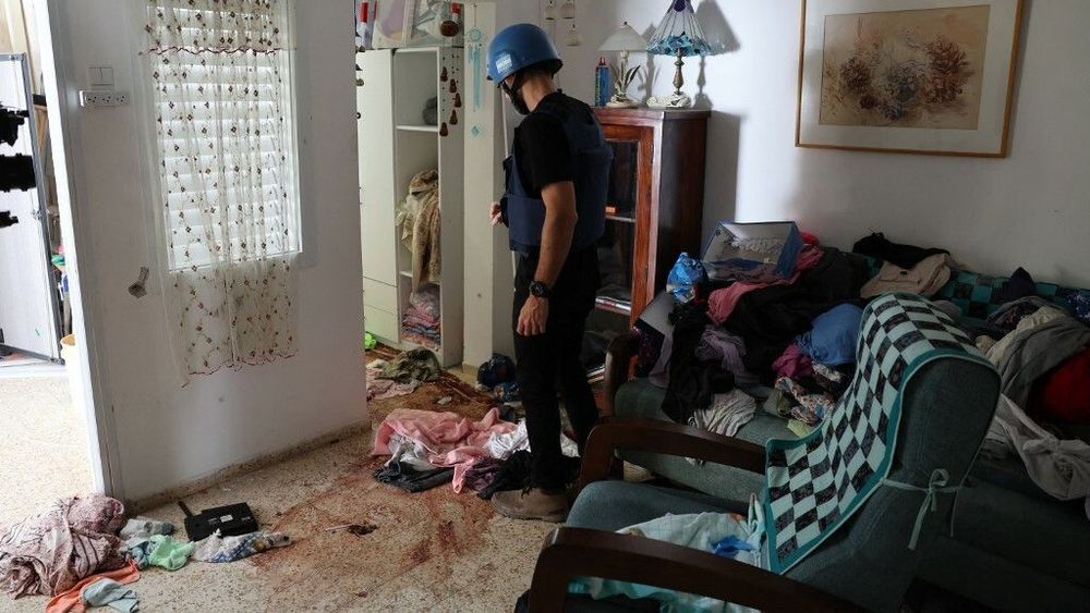 A foreign journalist checks blood stains on the floor of a house inside the kibbutz Nir Oz along the border with the Gaza Strip on October 19, 2023, following the October 7 attack by Hamas militants.