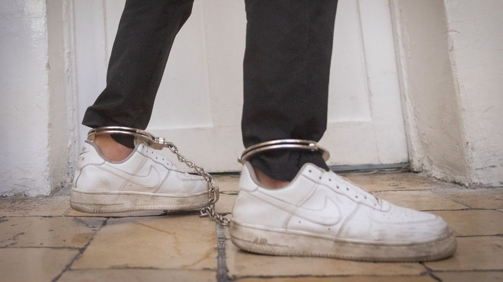 Handcuffed detainee in court, illustration