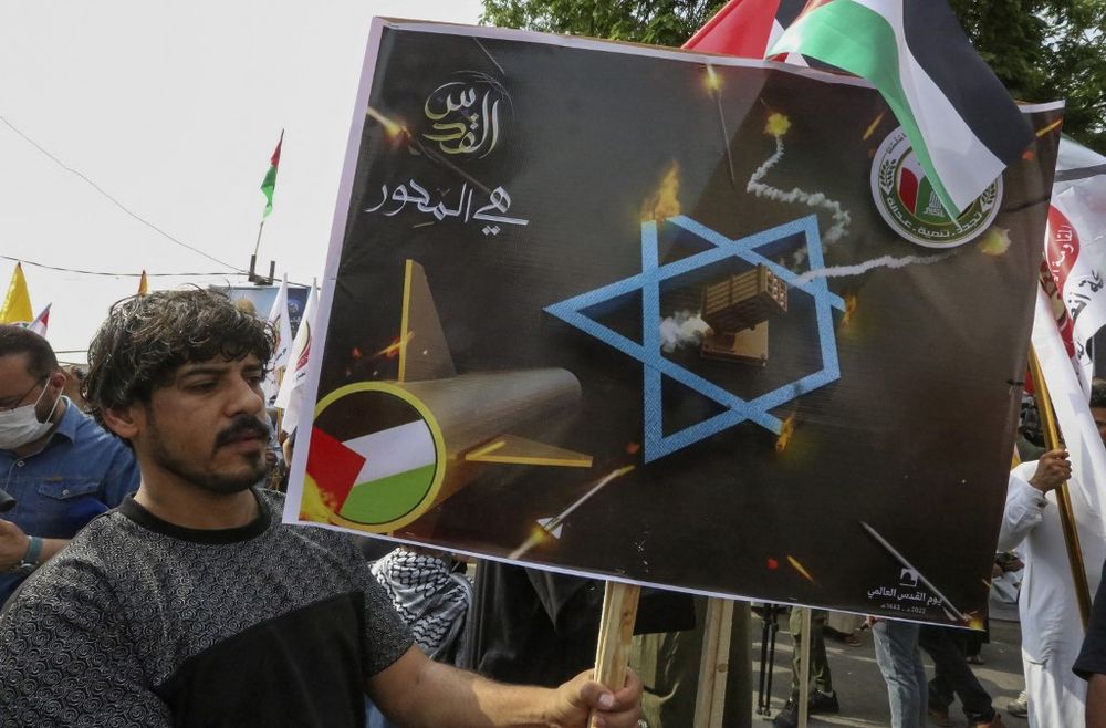 An Iraqi protester lifts an anti-Israel placard during a rally to mark Al-Quds (Jerusalem) day on Baghdad's Aba Nawas Street on April 29, 2022.