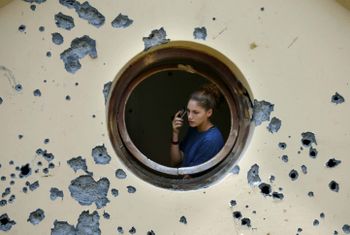 An Israeli woman checks the damages to her house after a rocket attack in the northern Israeli town of Karmiel, on July 15, 2006.