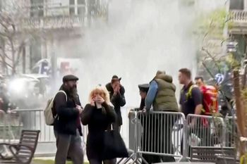 Bystanders react after witnessing a man who lit himself on fire was extinguished in a park outside Manhattan criminal court in New York.