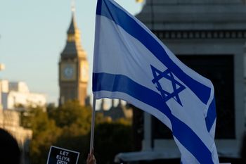 Israeli flags and placards are held during a protest in support of Israel in Trafalgar Square, London, United Kingdom.