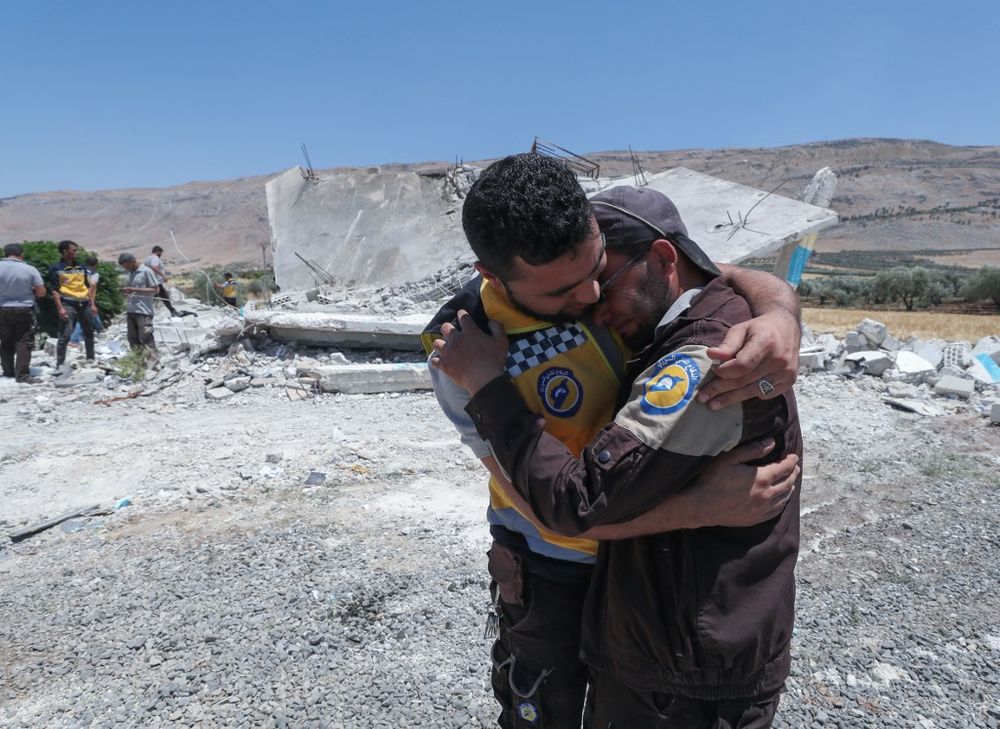 Members of the Syrian Civil Defense service, the White Helmets, mourn the death of a colleague in a reported bombardment from pro-regime forces in the Hama province, Syria, on June 19, 2021.