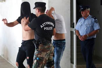Israeli teenagers accused of gang raping a British national cover their faces as they are escorted by Cypriot police, Cyprus.