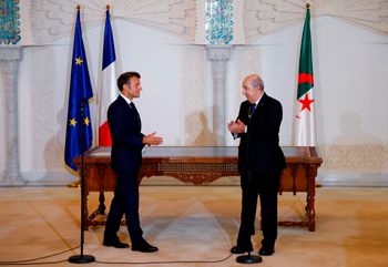 الرئيس الفرنسي إيمانويل ماكرون ، على اليسار ، يسير بينما يصفق الرئيس الجزائري عبد المجيد تبون خلال حفل توقيع في مطار الجزائر العاصمة ، السبت 27 أغسطس 2022.