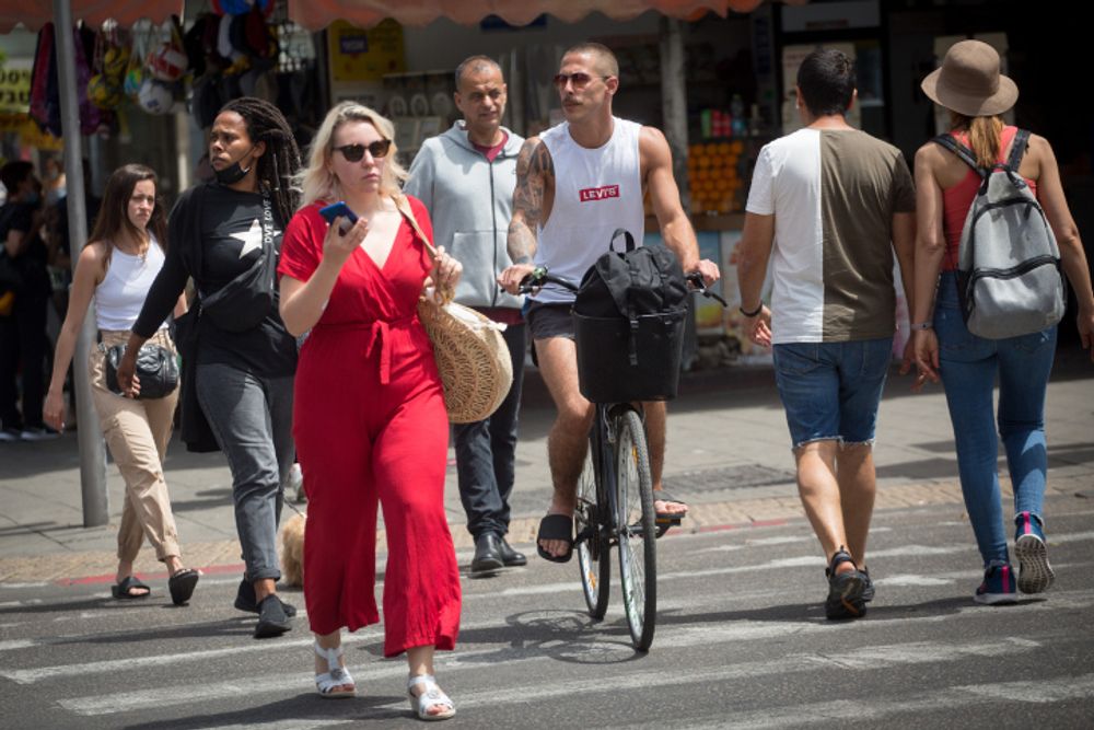 Israelis in Tel Aviv after the country lifts the restrictions on wearing a mask outdoors on April 18, 2021.