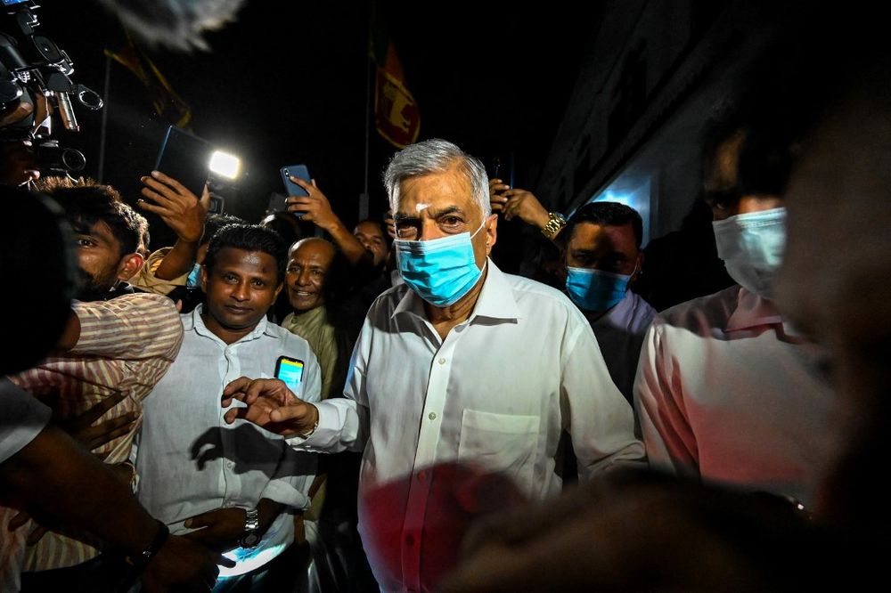 Sri Lanka's new prime minister Ranil Wickremesinghe (C) visits a Buddhist temple after his swearing in ceremony in Colombo, Sri Lanka, on May 12, 2022.