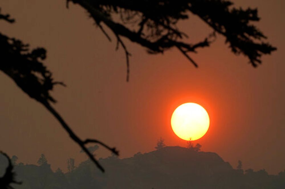 Smoke from the Caldor Fire obscures the sun as it sets over the mountains near South Lake Tahoe of California, the United States, August 24, 2021.