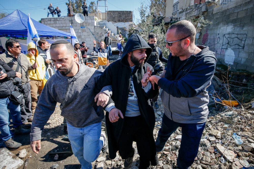 La police arrête un homme lors d'affrontements entre des hommes juifs et des Palestiniens dans le quartier de Sheikh Jarrah à Jérusalem-Est, le 13 février 2022