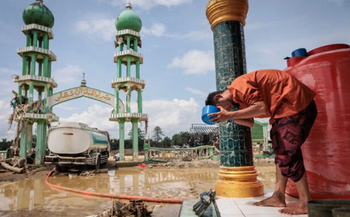 Un musulman se lave le visage avant d'assister à la prière du vendredi à la mosquée Al Ihsan, partiellement endommagée par les inondations, à Aceh Tamiang, dans le nord de Sumatra, en Indonésie, le 12 décembre 2025.