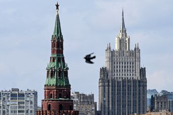 A pigeon flies past one of the Kremlin towers and the Russian Foreign Ministry headquarters in Moscow on April 5, 2022.
