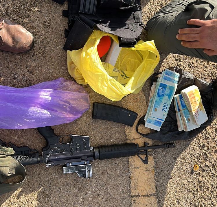 An M-16 assault rifle and cash seized by Israeli security forces during the arrest of a Palestinian terror suspect in the West Bank.