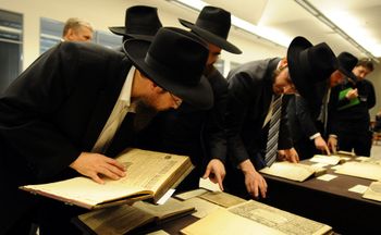 Members of Jewish community look at the books from of the Schneerson library displayed in the Jewish Museum and Tolerance Centre in Moscow, Russia, on June 13, 2013.
