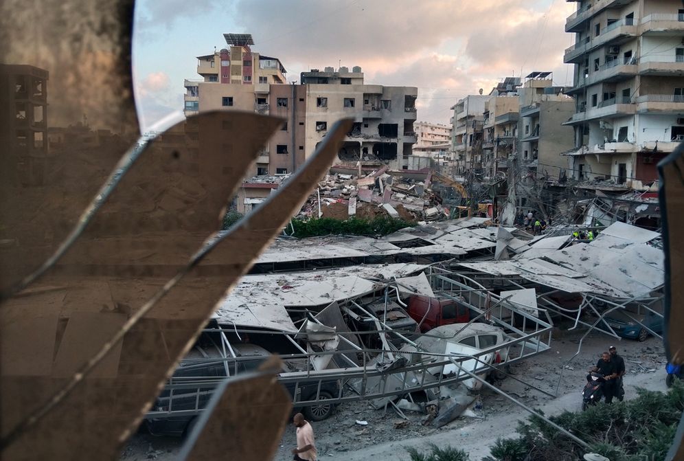 A destroyed building that was hit in an Israeli airstrike is seen through a shattered window of the Jabal Amel Hospital, in the southern port city of Tyre, Lebanon, Monday, June 1, 2026. 