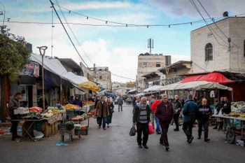 Des Palestiniens font leurs courses pendant le mois sacré du Ramadan, sur un marché de la ville d'Hébron en Cisjordanie, le 24 mars 2024