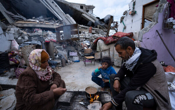 Des Palestiniens rompent leur jeûne pendant le mois sacré du Ramadan devant leur maison détruite à Rafah, dans la bande de Gaza, le 18 mars 2024.