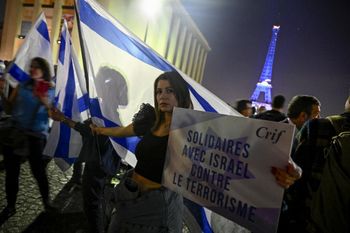 Des manifestants au Trocadéro devant la Tour Eiffel, illuminée aux couleurs du drapeau national d'Israël, à Paris le 9 octobre 2023
