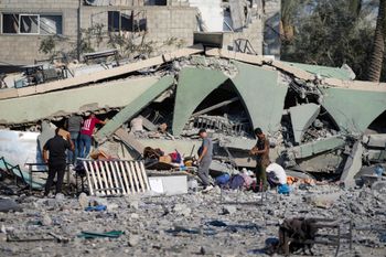 Palestinians inspect the rubble of a school destroyed in an Israeli airstrike on Deir al-Balah, central Gaza Strip
