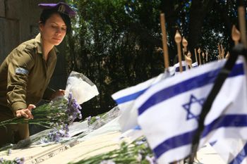 Des soldats israéliens se tiennent à côté des tombes de militaires tombés au combat pendant les préparatifs de la cérémonie au cimetière militaire du Mont Herzl à Jérusalem.