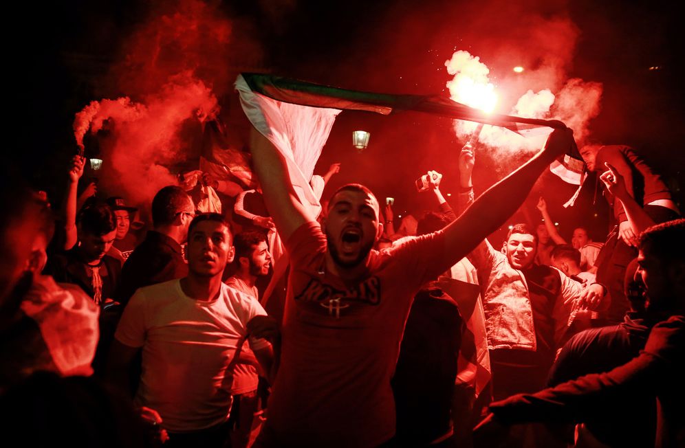 Les supporters algériens célèbrent la victoire de l'Algérie en demi-finale de football de la Coupe d'Afrique des Nations (CAN) 2019 contre le Nigeria, sur l'avenue des Champs-Élysée à Paris le 14 juillet 2019