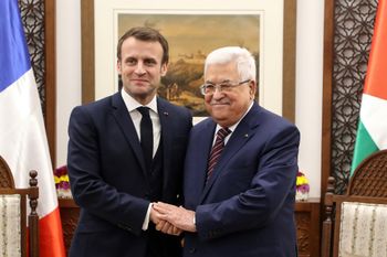French President Emmanuel Macron (L) shakes hands with Palestinian President Mahmoud Abbas at his headquarters in the West Bank city of Ramallah, on January 22, 2020.