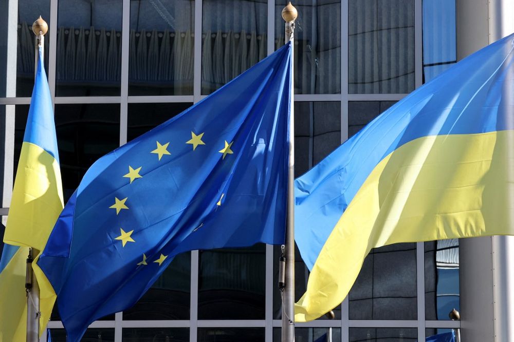 The Ukrainian flag flutters along side the European Union flag outside the European Parliament headquarters in Brussels, Belgium.