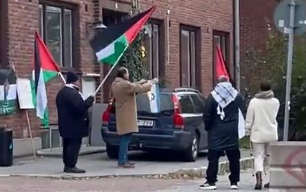 Un homme brûle un drapeau israélien devant la synagogue de Malmö.