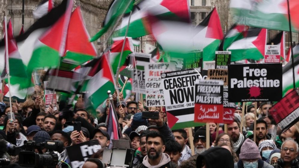 Pro-Palestinian protesters hold up banners, flags and placards during a demonstration in London, UK.