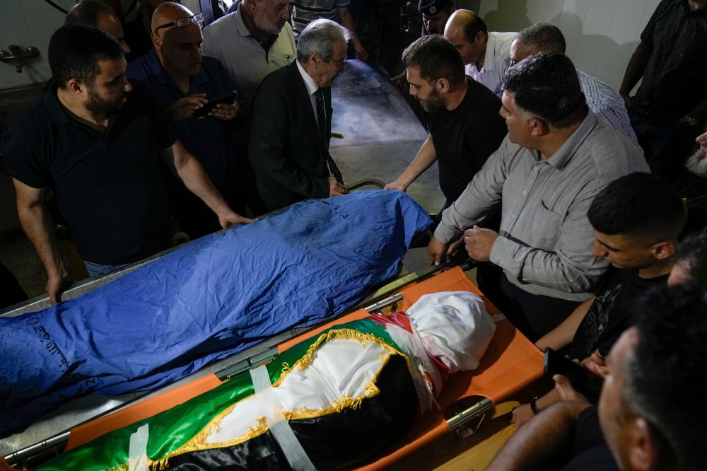 Palestinian mourners gather around the covered bodies of Turkish-American Aysenur Ezgi Eygi, 26, and Palestinian Bana Bakr, 13, at a morgue in Nablus, West Bank