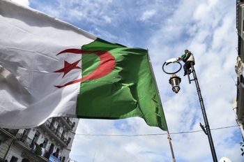 This picture taken on March 22, 2019 shows an Algerian national flag flying during a demonstration against ailing President Abdelaziz Bouteflika in the capital Algiers.
