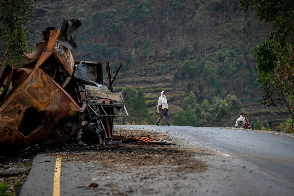 A man crosses near a destroyed truck on a road leading to the town of Abi Adi, in the Tigray region of northern Ethiopia, on May 11, 2021.
