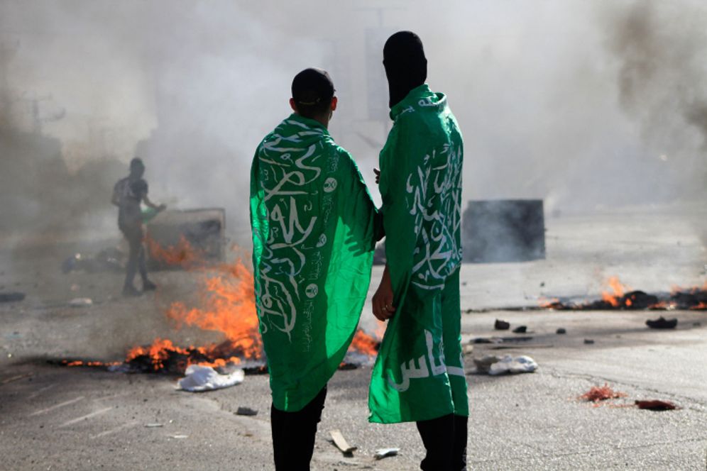 Adorned in Hamas flags, Palestinians clash with Israeli soldiers near Nablus in the West Bank, October 13, 2023.