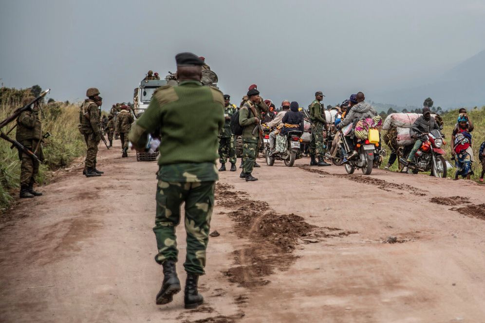 People walk near Kibumba, north of Goma, the Democratic Republic of Congo, as they flee fighting between Congolese forces and M23 rebels, on May 24, 2022.