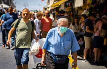Des personnes, dont certaines portent un masque, font leurs courses au marché de Mahane Yehuda à Jérusalem, le 7 juillet 2022.