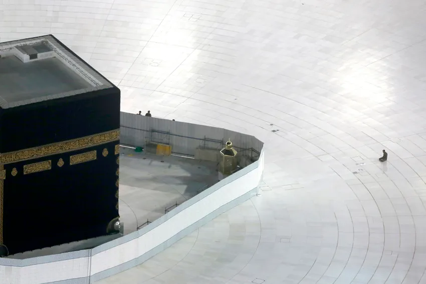 A Saudi policeman prays in front of the Kaaba, the cubic building at the Grand Mosque, in the Muslim holy city of Mecca, Saudi Arabia, Saturday, March 7, 2020.