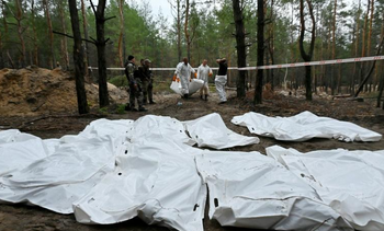 Des corps exhumés dans une forêt près d'Izioum, le 16 septembre 2022 dans l'est de l'Ukraine
