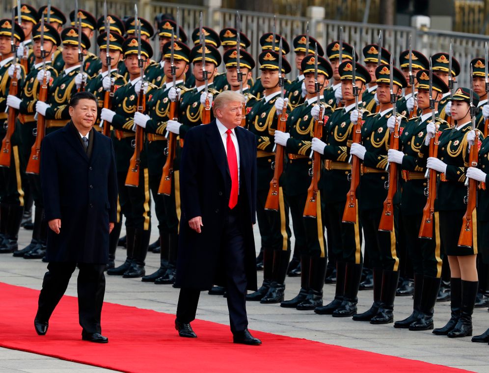 FILE - U.S. President Donald Trump, right, and Chinese President Xi Jinping inspect a honor guard during a welcome ceremony at the Great Hall of the People in Beijing, Nov. 9, 2017. 
