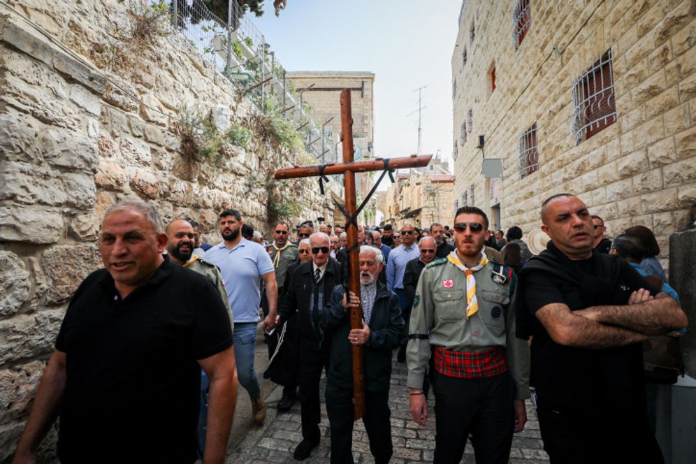Catholic worshippers hold crosses as they take part in a Good Friday procession  in Jerusalem's Old City.