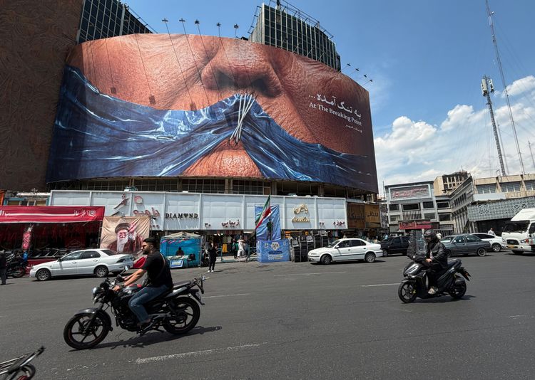 Panneau d'affichage présentant une image du détroit d'Ormuz et des lèvres cousues du président américain Donald Trump, sur une place du centre-ville de Téhéran, en Iran, le samedi 2 mai 2026.